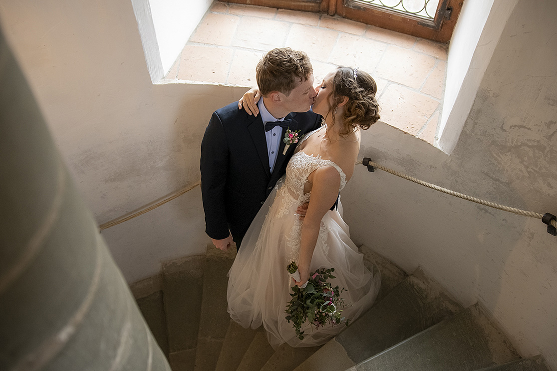 Brautpaar küsst sich in Treppenaufgang