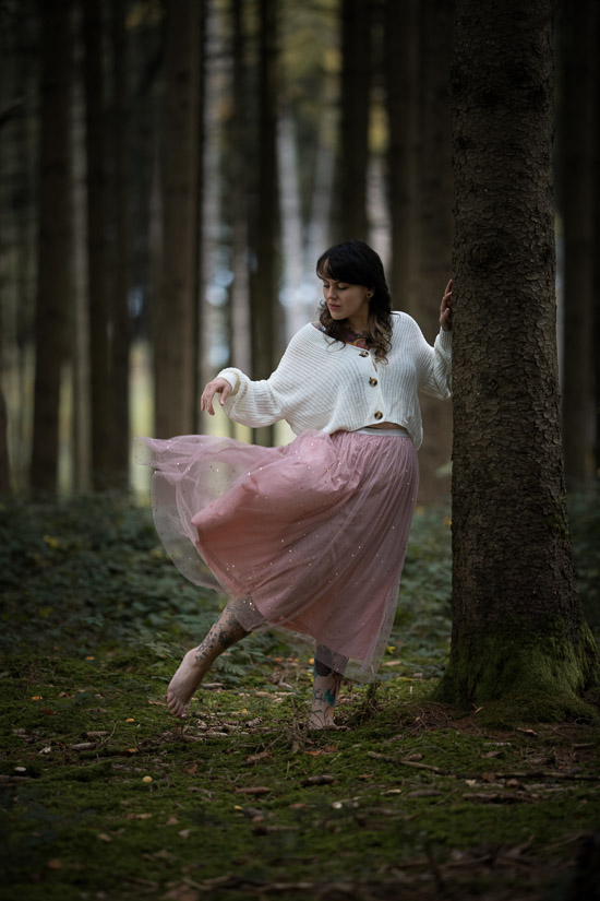 Model spielt mit ihrem Tüllrock im Wald