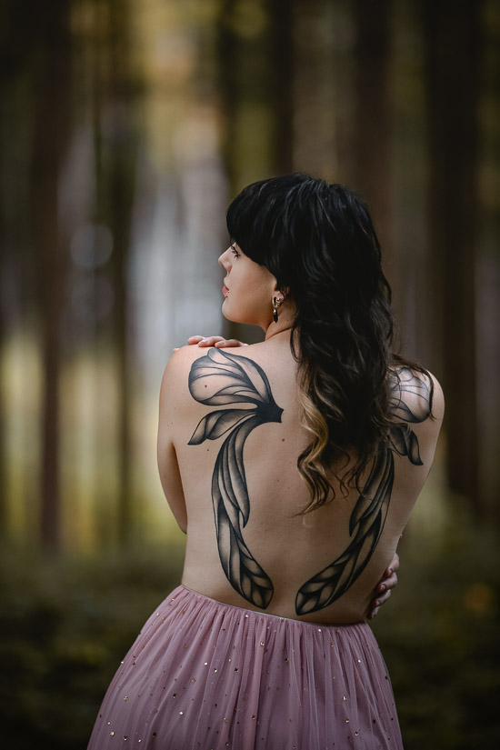 Portrait von hinten mit Tattoos am Rücken